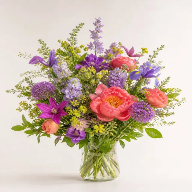 Bright violet, coral, and yellow seasonal flower arrangement