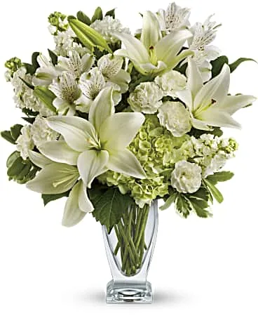 White and ivory sympathy bouquet with lilies and hydrangea in a clear glass vase