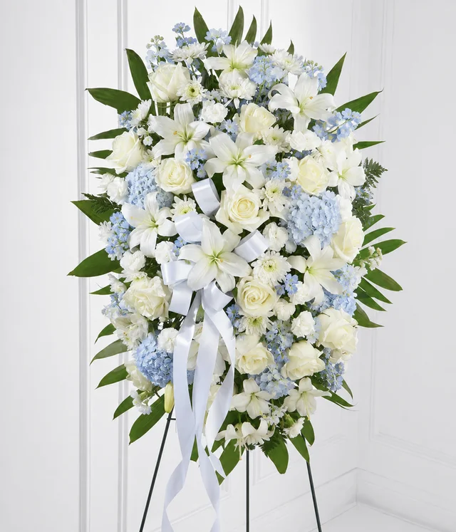 Powder blue standing spray with cream white roses, lilies and carnations