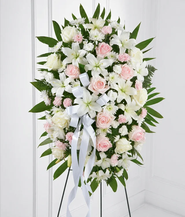 Blush pink roses and carnations with white lilies in the original standing spray